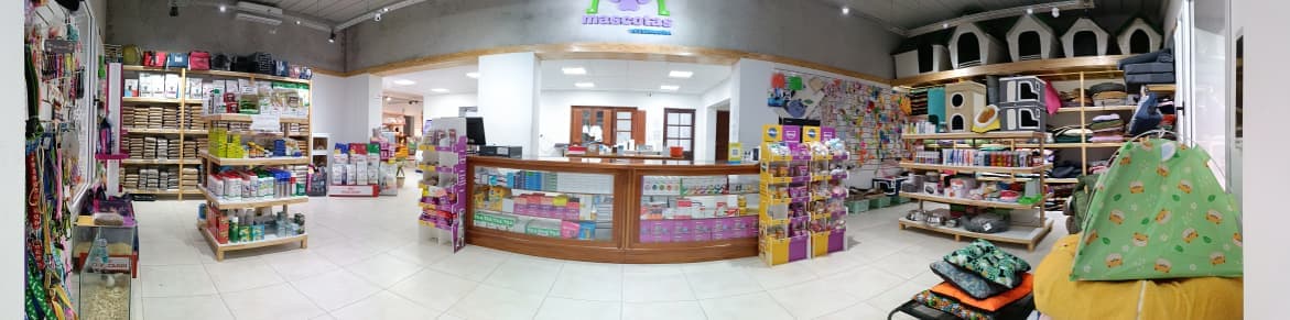 Interior del local de Veterinaria Mascotas: mostrador de atención y estanterías con productos del pet shop
